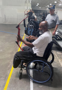 a military veteran pulls back a bow string